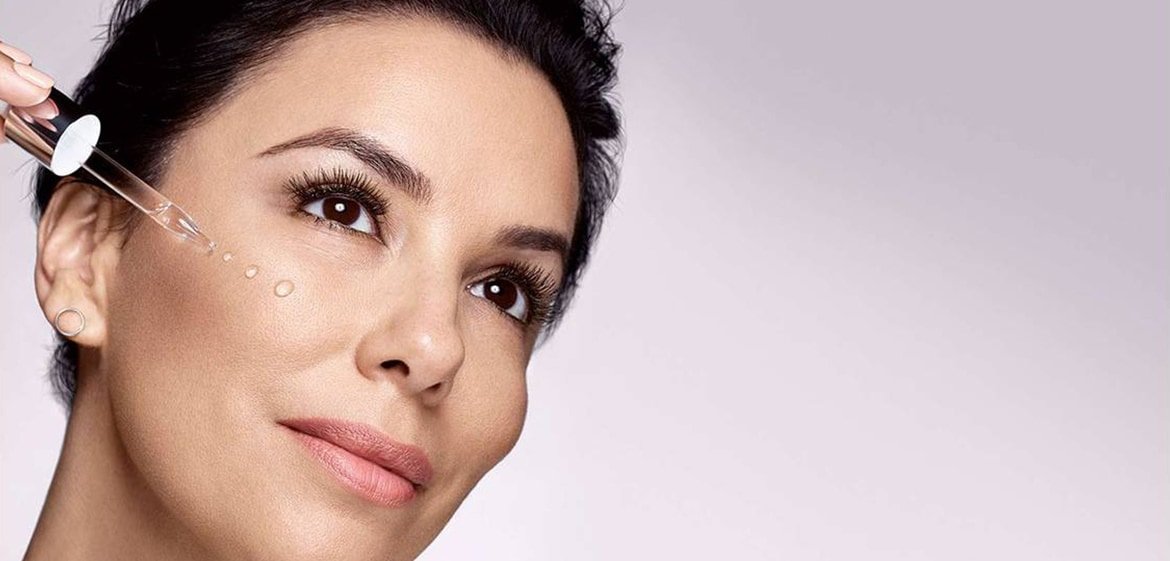 Eva Longoria trägt Serum aus einer Pipette auf ihre Wange auf